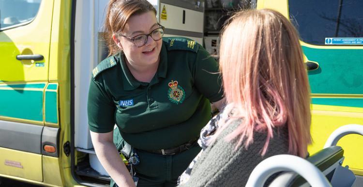 Paramedic speaking to patient in wheelchair