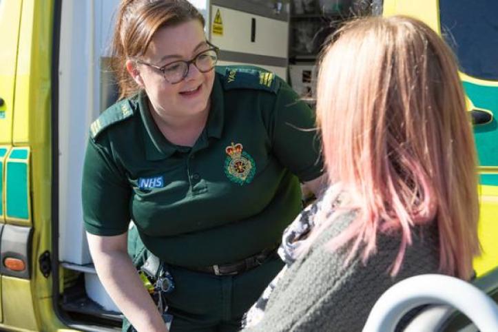 Paramedic speaking to patient in wheelchair
