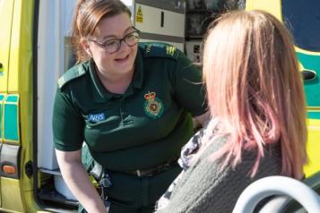 Paramedic speaking to patient in wheelchair