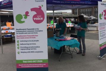 Image of staff setting up a Healthwatch stall on Ashton market 