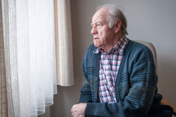 Man seated next to window