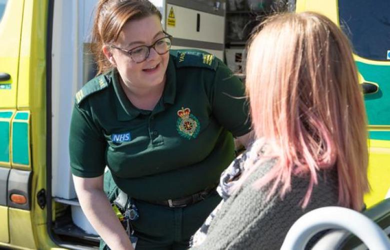 Paramedic speaking to patient in wheelchair